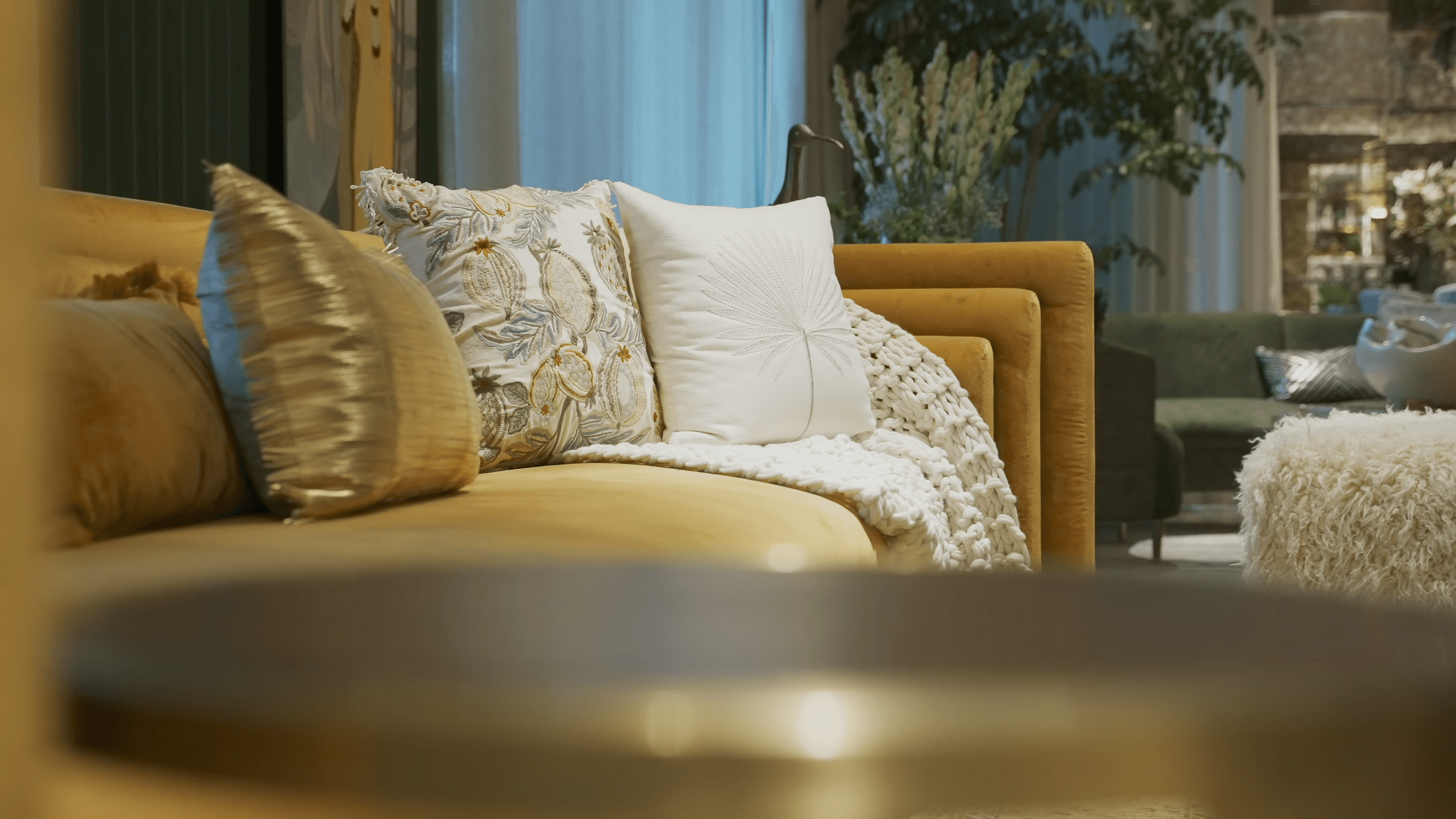 Artisan cushions and a knitted throw on a golden sofa