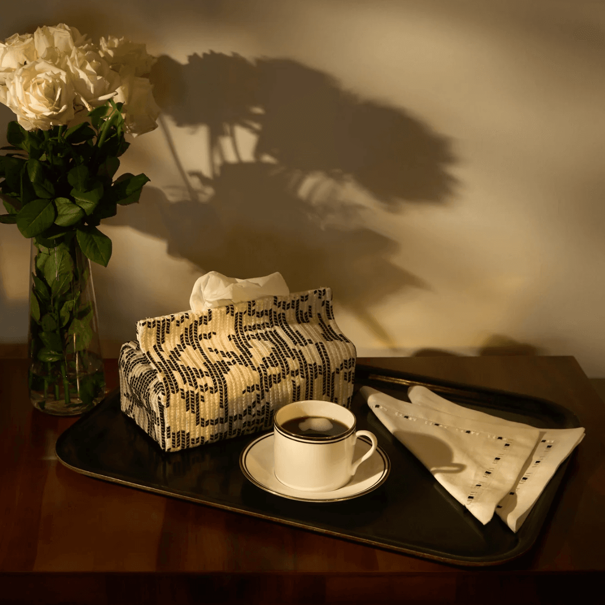 Patterned cushions beside a vase and a warmly lit table