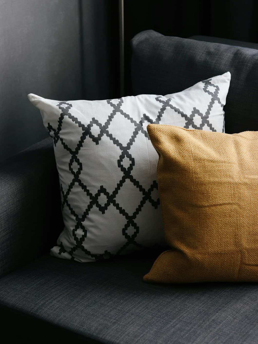 Graphic black-and-white cushions beside a warm gold cushion