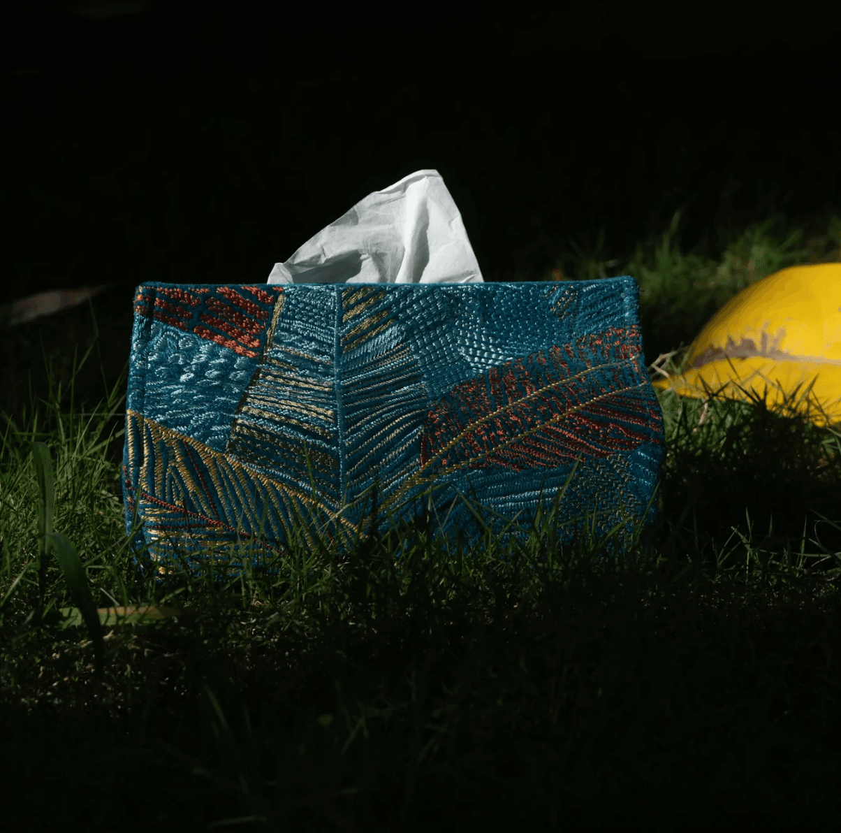 Rich blue patterned textiles and a yellow cushion in a lush interior