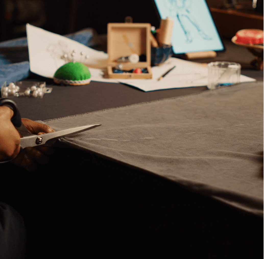 An artisan's worktable with fabrics, sketches and materials